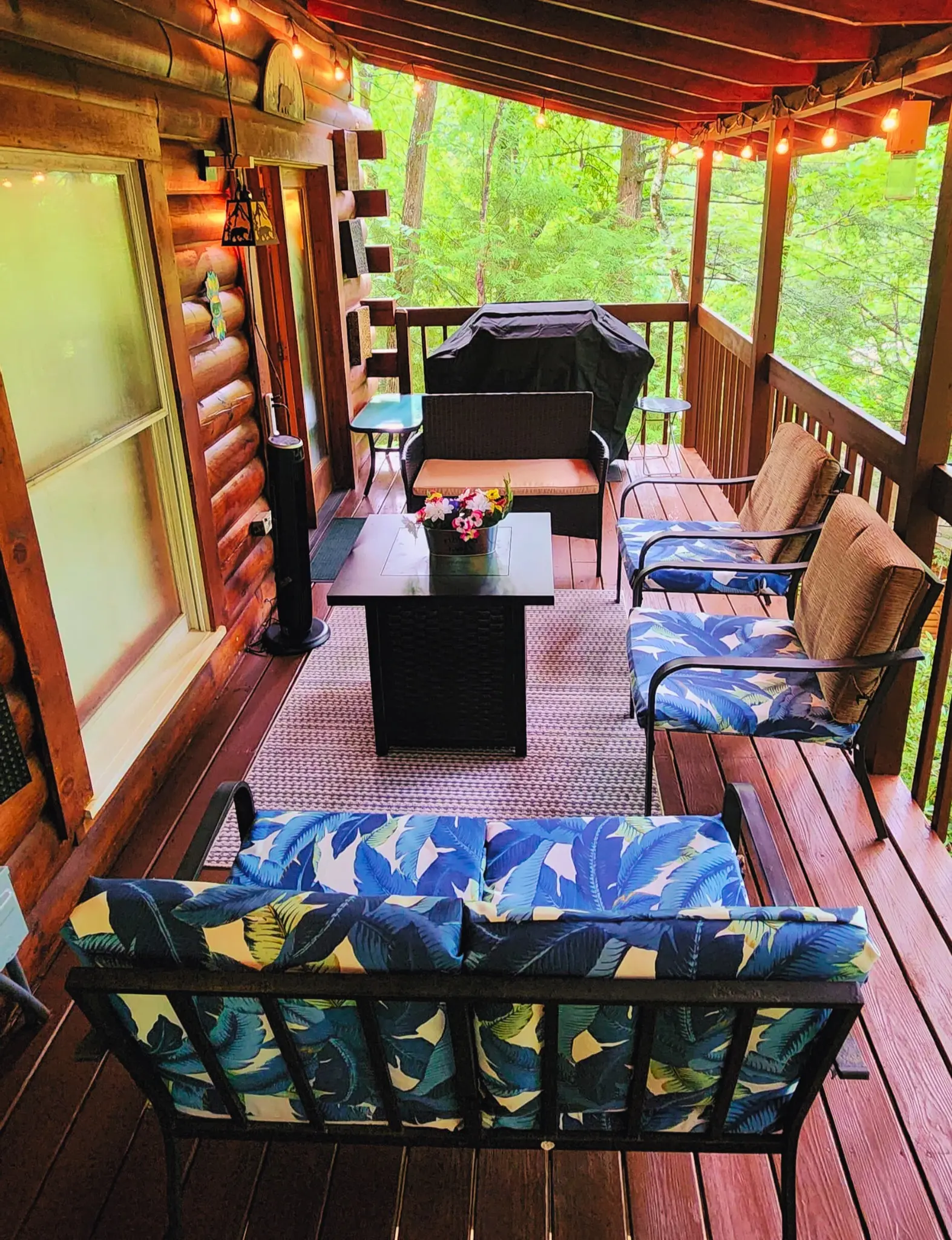 Covered deck seating surrounded by trees at Heavenly Heights