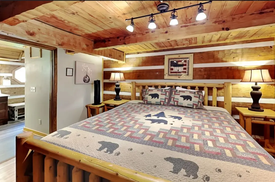 Rustic bedroom with log bed and bear quilt at Peaceful Ridge