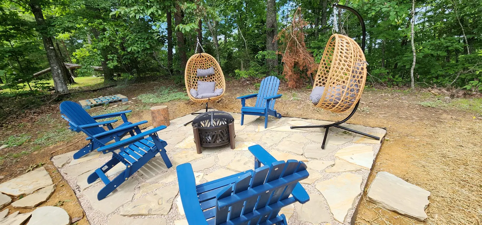 Hanging egg chairs and Adirondack chairs in the woods